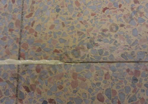 Terrazzo tile joint being filled with fast setting resin